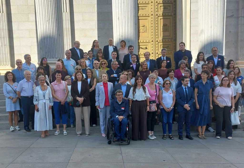 Representantes del sector de la discapacidad y la dependencia posan en las escalinatas del Congreso de los Diputados antes de asistir a la aprobación definitiva de las reformas de ambas leyes.