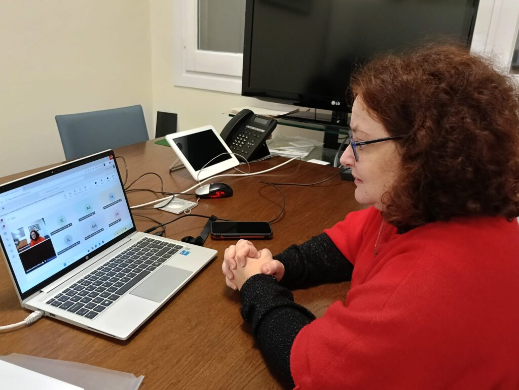 Raquel Cárcamo, codirectora del CEACOG, sentada frente a un ordenador portátil desde el que imparte una formación online sobre accesibilidad cognitiva a personal del Ministerio de Política Territorial y Memoria Democrática.
